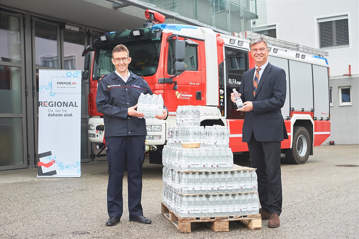 Generaldirektor Werner Steinecker übergibt das Mineralwasser an Landes-Feuerwehrkommandant Robert Mayer.