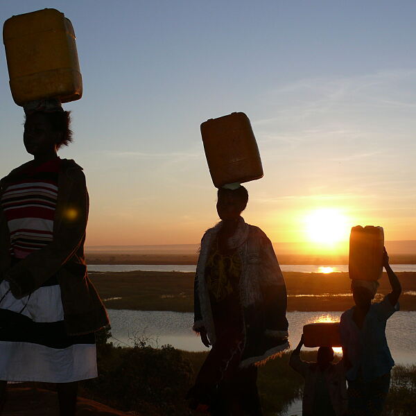 Charity-Aktion Wassertropfen: Frauen tragen Wasserkanister von den sauberen Wasserstellen in der Demokratischen Republik Kongo nach Hause.